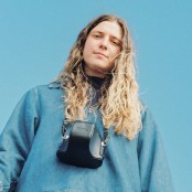 Rosie H Sullivan in a denim jacket with a camera around her neck